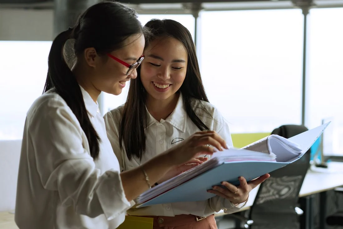 Hai nữ nhân viên nhân sự cùng rà soát hồ sơ nhân viên tại văn phòng, dịch vụ tính lương
